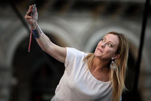 رهبر حزب راست افراطی ایتالیایی Fratelli d'Italia (برادران ایتالیا) جورجیا ملونی، در حال گرفتن عکس سلفی در جریان یک گردهمایی به عنوان بخشی از کمپین انتخابات عمومی، در میدان دومو در میلان، ایتالیا در 11 سپتامبر 2022 - اسپوتنیک ایران  