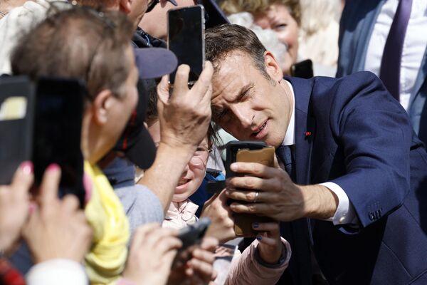 رئیس جمهور فرانسه، امانوئل ماکرون، هنگام ورود برای رای دادن در دور دوم انتخابات ریاست جمهوری فرانسه در یک مرکز رای گیری در لو توکه، شمال فرانسه، در ۲۴ آوریل ۲۰۲۲ - اسپوتنیک ایران  