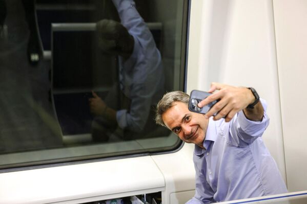 نخست وزیر یونان، کیریاکوس میتسوتاکیس، در حالی که سوار متروی تسالونیکی می شود، در حین اجرای آزمایشی آن با مسافران در تسالونیکی، شمال یونان، در 18 مه 2023، پیش از انتخابات عمومی یونان که برای 21 مه برنامه ریزی شده است، سلفی می گیرد.  - اسپوتنیک ایران  