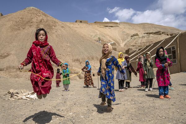 بازی دختران مدرسه‌ای در محوطه یک مدرسه روستایی در بامیان افغانستان، یکشنبه 18 ژوئن 2023. - اسپوتنیک ایران  