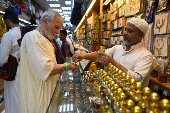 در 24 ژوئن 2023، در حالی که مسلمانان از سراسر جهان برای زیارت سالانه حج وارد می شوند، زائران در بازاری در مکه خرید می کنند. (Photo by Sajjad HUSSAIN / AFP) - اسپوتنیک ایران  