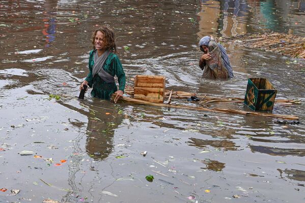 پس از بارندگی شدید در لاهور در 26 ژوئن 2023، کودکان در یک بازار سیل زده  - اسپوتنیک ایران  