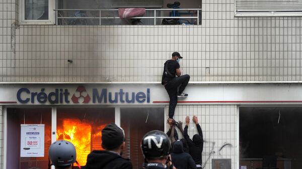 Протестующий взбирается на здание во время демонстрации в Нантере, Франция - اسپوتنیک ایران  