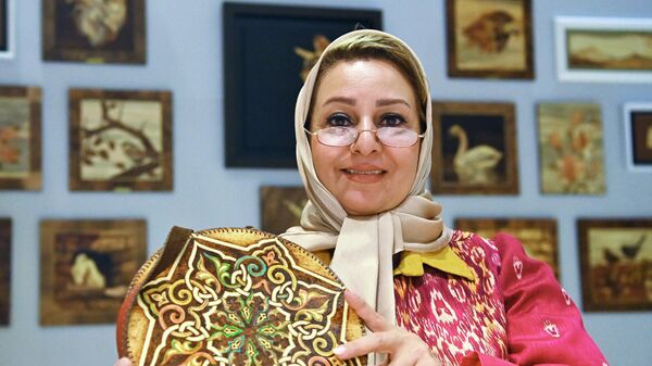 Участница выставки демонстрирует изделие из кожи на одном из стендов на выставке иранского искусства в рамках проекта Обменные культурные мероприятия России и Ирана на ВДНХ - اسپوتنیک ایران  