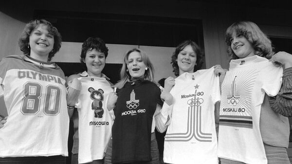 Сотрудницы швейной фабрики под Штутгартом, Германия, держат в руках пять разных футболок с эмблемами Московской Олимпиады 1980 года - اسپوتنیک ایران  