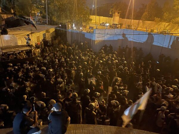 معترضان در بالای ساختمانی در کنار سفارت سوئد در بغداد نشسته اند. - اسپوتنیک ایران  