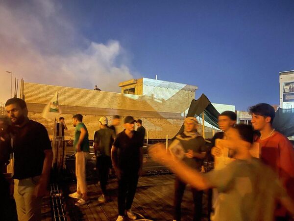 معترضان در بالای ساختمانی در کنار سفارت سوئد در بغداد ایستاده اند. - اسپوتنیک ایران  