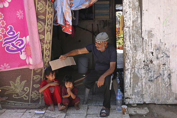 پدر فلسطینی در حال باد زدن فرزندش برای خنک کردن او. نوار غزه. پدر فلسطینی در حال باد زدن فرزندش برای خنک کردن او. نوار غزه. - اسپوتنیک ایران