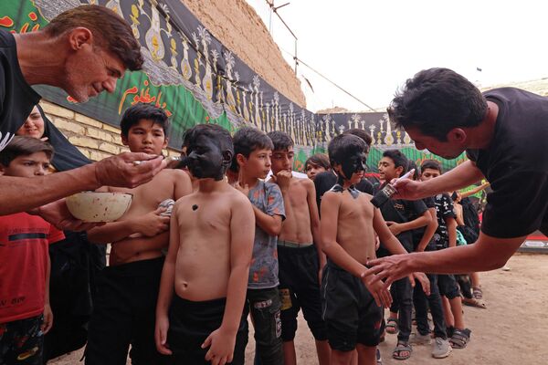 پسران در آستانه اجرای مراسم سالانه تعزیه در شهر نوش آباد، ایران صورت و گردنشان را سیاه رنگ می کنند. 26 جولای 2023. - اسپوتنیک ایران  