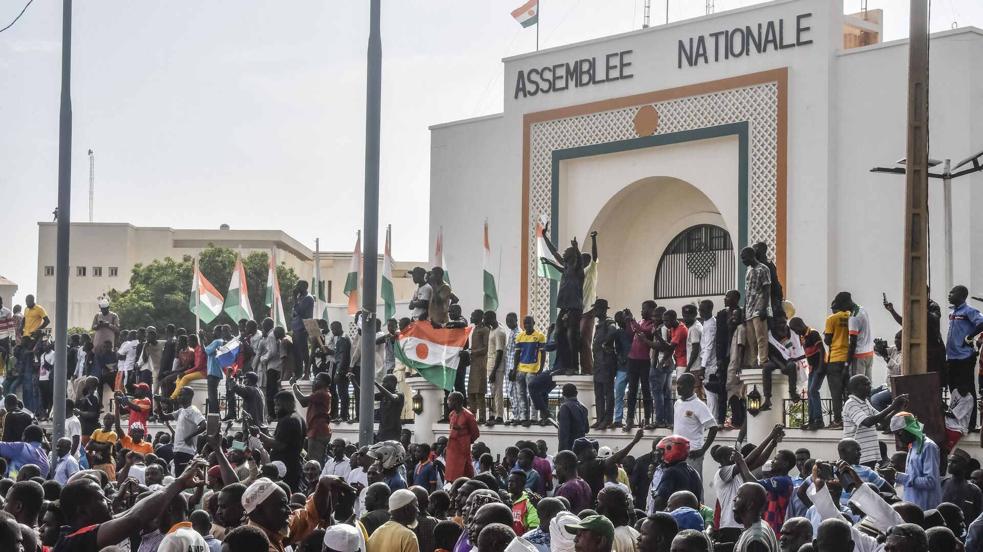 Сторонники размахивают флагами Нигерии, митингуя в поддержку нигерийской хунты перед зданием Национальной ассамблеи в Ниамее - اسپوتنیک ایران  , 1920, 19.08.2023