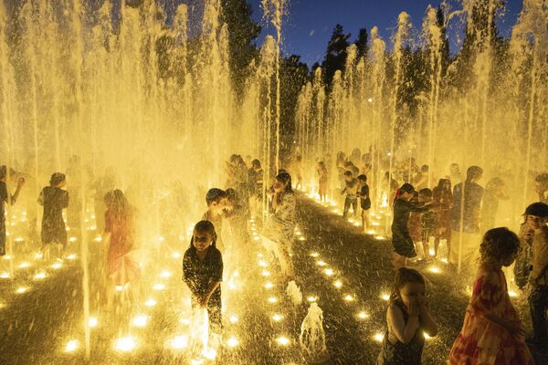 کودکان یهودی فوق ارتدوکس همراه با سایر جوانان در گرمای تابستان در فواره های آب در اورشلیم خنک می شوند. 1 آگوست 2023 - اسپوتنیک ایران  