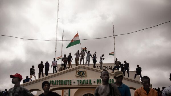 Protesters hold a Niger flag during a demonstration on independence day in Niamey on August 3, 2023. Hundreds of people backing the coup in Niger gathered on August 3, 2023 for a mass rally in the capital Niamey with some brandishing giant Russian flags. - اسپوتنیک ایران  