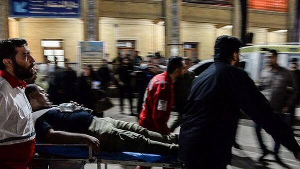 Медики переносят раненого мужчину в машину скорой помощи на месте стрельбы в мавзолее Шах-Черах в иранском Ширазе - اسپوتنیک ایران  
