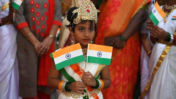 دختری خردسال با پرچم های ملی هند در روز استقلال هند در حیدرآباد - اسپوتنیک ایران  