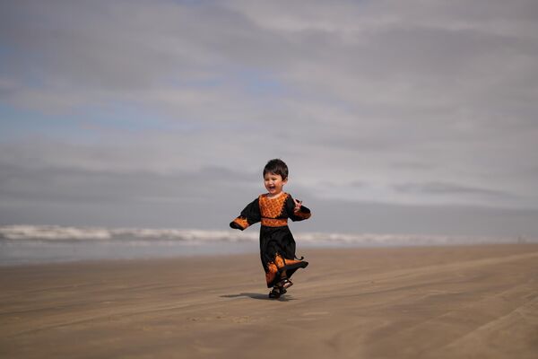 فرنیا حسنی، پناهجوی دو ساله افغان، در حال بازی کردن در ساحل پرایا گراند، ایالت سائوپائولو، برزیل. - اسپوتنیک ایران  