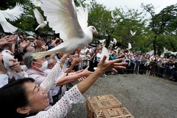 کبوترها با دعای صلح توسط عبادت کنندگان در معبد یاسوکونی در توکیو، ژاپن آزاد می شوند. - اسپوتنیک ایران  