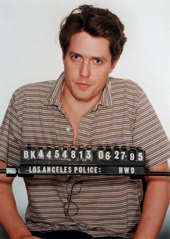 تصویر هیو گرانت، هنرپیشه بریتانیایی، در ۲۷ ژوئن ۱۹۹۵، پس از دستگیری  به دلیل رفتار نادرست با یک فاحشه در بلوار سانست در هالیوود، در اداره پلیس لس آنجلس - اسپوتنیک ایران  