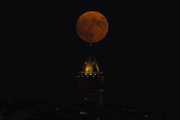 ماه کامل در پشت برج گالاتا در استانبول، ترکیه، چهارشنبه، آگوست طلوع می کند. 30، 2023. پرده کیهانی چهارشنبه شب با دومین ماه کامل ماه برخاست، به همین دلیل آبی در نظر گرفته شده است. به آن ابرماه لقب داده اند زیرا از حد معمول به زمین نزدیک تر است و به خصوص بزرگ و درخشان به نظر می رسد. (عکس آسوشیتدپرس/خلیل حمرا) - اسپوتنیک ایران  