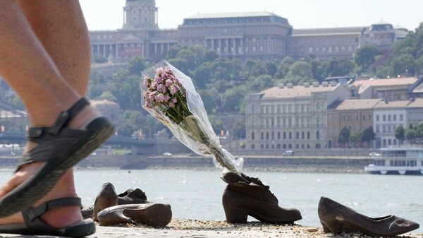 Люди оставляют цветы у мемориала Еврейская обувь на берегу Дуная в память об убитых будапештских евреях во время Второй Мировой Войны, Венгрия - اسپوتنیک ایران  