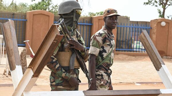 Nigerien soldiers stand guard as supporters of Niger's National Council of Safeguard of the Homeland (CNSP) protest outside the Niger and French airbase in Niamey on August 30, 2023 to demand the departure of the French army from Niger. - اسپوتنیک ایران  