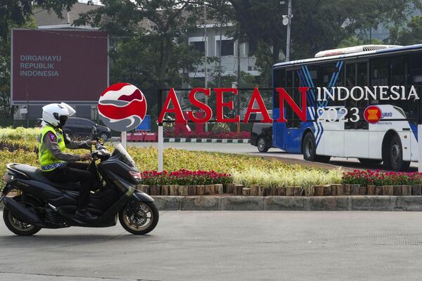 یک افسر پلیس در جاکارتا، اندونزی، جمعه، 1 سپتامبر 2023، سوار بر موتور خود از کنار لوگوی ASEAN 2023 می گذرد.  - اسپوتنیک ایران  