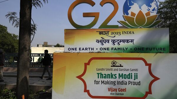 A commuter walks past a G20 logo at a crossing in New Delhi, India, Tuesday, Feb. 28, 2023. - اسپوتنیک ایران  