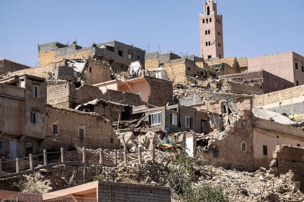 مناره یک مسجد در پشت خانه های آسیب دیده یا ویران شده در پی زلزله در مولای براهیم، استان الحوض، در 9 سپتامبر 2023 قرار دارد.(Photo by FADEL SENNA / AFP) - اسپوتنیک ایران  