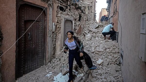 Женщина эвакуируется со своими вещами в пострадавшем от землетрясения старом городе Марракеша, Марокко  - اسپوتنیک ایران  