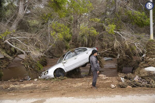 در این عکس ارائه شده توسط دولت لیبی، خودرویی که در روز دوشنبه، 11 سپتامبر 2023 توسط سیل در درنا لیبی توسط آب های سیلابی در لیبی حمل شد، در درختان گیر افتاده است. طوفان مدیترانه ای دانیل باعث سیل ویرانگر در لیبی شد که سدها را شکست و کل محله ها را با خود برد. - اسپوتنیک ایران  