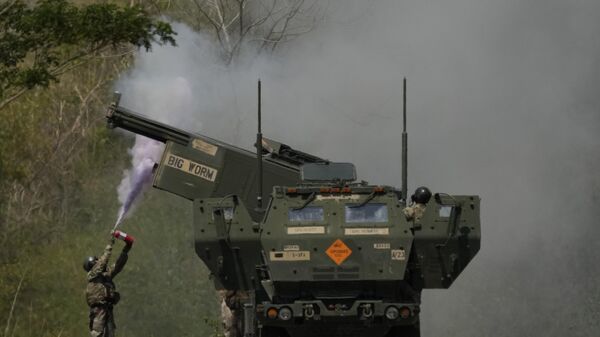 A US soldier extinguishes a fire on one fo the tubes on a U.S. M142 High Mobility Artillery Rocket System (HIMARS) after firing missiles during a joint military drill between the Philippines and the U.S. called Salaknib at Laur, Nueva Ecija province, northern Philippines on Friday, March 31, 2023. - اسپوتنیک ایران  