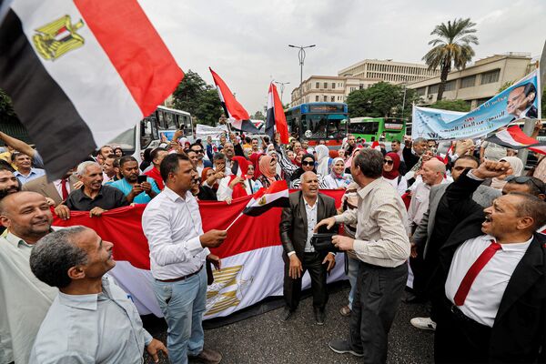 حامیان عبدالفتاح السیسی، رئیس جمهور مصر، با پرچم های ملی و سردادن شعارهایی در  یک گردهمایی تبلیغاتی انتخاباتی در خارج از محوطه دانشگاه قاهره در شهر جیزه، شهر دوقلوی پایتخت مصر، در 2 اکتبر 2023 تجمع کردند. - اسپوتنیک ایران  