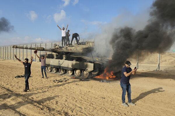 شادی فلسطینیان در کنار تانک منهدم شده اسرائیلی در شرق خان یونس. - اسپوتنیک ایران  