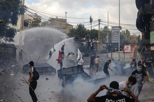 نیروهای امنیتی لبنان هنگام درگیری با معترضان خارج از سفارت آمریکا در عوکار در شرق بیروت، در جریان تظاهرات همبستگی با فلسطینیان نوار غزه در 18 اکتبر 2023، از ماشین های آب پاش استفاده می کنند. هزاران نفر در سراسر جهان عرب و اسلام در ماه اکتبر تظاهرات کردند. 18 در اعتراض به کشته شدن صدها نفر در اعتصاب به بیمارستانی در غزه که اسرائیل را علیرغم انکار آن مقصر می دانند. (عکس از ابراهیم امرو / خبرگزاری فرانسه) - اسپوتنیک ایران  