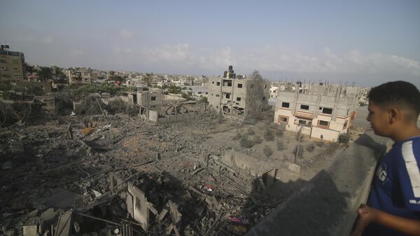 Мальчик смотрит на здания, разрушенные в результате израильской бомбардировки сектора Газа в Рафахе - اسپوتنیک ایران  