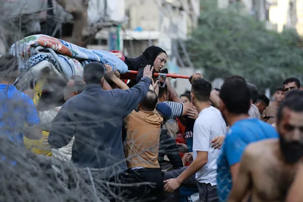 فلسطینیان در پی حمله اسرائیل به شهر غزه در 10 اکتبر 2023، یک زن مجروح را تخلیه می کنند..اعضای جنبش حاکم حماس در نوار غزه روز شنبه 7 اکتبر حمله بی سابقه ای را به اسرائیل انجام دادند که در آن بیش از 900 نفر کشته و اسیر شدند. به دنبال آن اسرائیل حملات هوایی تلافی جویانه سنگینی را به این منطقه انجام داد و صدها فلسطینی را به قتل رساند. فلسطینیان در پی حمله اسرائیل به شهر غزه در 10 اکتبر 2023، یک زن مجروح را تخلیه می کنند..اعضای جنبش حاکم حماس در نوار غزه روز شنبه 7 اکتبر حمله بی سابقه ای را به اسرائیل انجام دادند که در آن بیش از 900 نفر کشته و اسیر شدند. به دنبال آن اسرائیل حملات هوایی تلافی جویانه سنگینی را به این منطقه انجام داد و صدها فلسطینی را به قتل رساند. - اسپوتنیک ایران