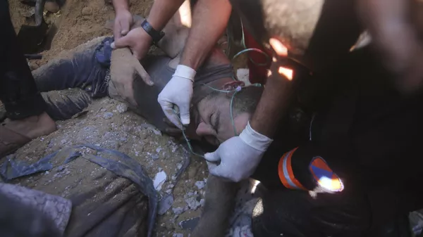 Палестинцы спасают раненого мужчину из-под обломков разрушенного здания в результате израильского авиаудара в Рафахе, сектор Газа - اسپوتنیک ایران  