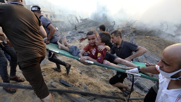 Палестинцы эвакуируют двух раненых мальчиков из разрушенного в результате израильских авиаударов по городу Газа - اسپوتنیک ایران  