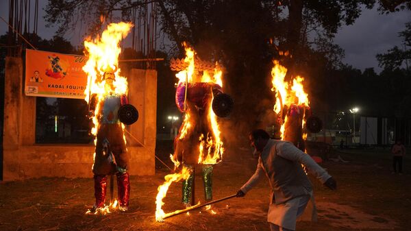 Мужчина поджигает чучела короля демонов Раваны, его брата Кумбхакарны и его сына Мегханады, отмечая окончание фестиваля Душера в Сринагаре, Кашмир - اسپوتنیک ایران  