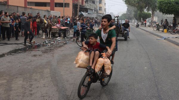 Мужчина с детьми и хлебом на велосипеде в Рафахе на юге сектора Газа - اسپوتنیک ایران  