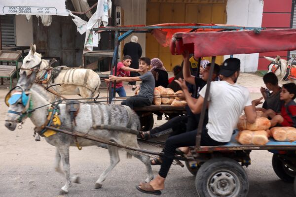  مردم در حالی که سوار گاری هستند، نان حمل می کنند.  - اسپوتنیک ایران  