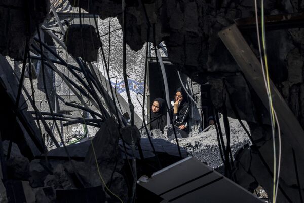 زنان در حالی که از پنجره به بیرون نگاه می کنند در ساختمانی در زمان بمباران رفح در جنوب نوار غزه توسط اسرائیل در 31 اکتبر 2023 در بحبوحه نبردهای جاری بین اسرائیل و جنبش فلسطینی حماس. - اسپوتنیک ایران  