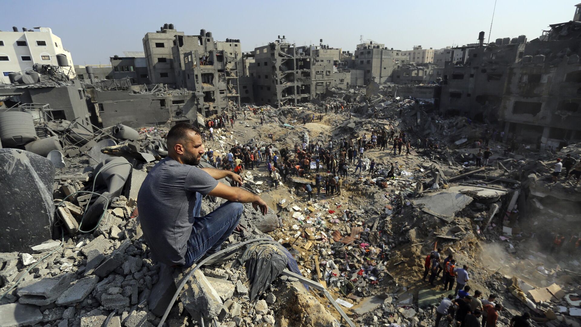 Мужчина сидит на обломках среди руин зданий, которые подверглись израильским авиаударам в лагере беженцев Джабалия на севере сектора Газа - اسپوتنیک ایران  , 1920, 11.11.2023
