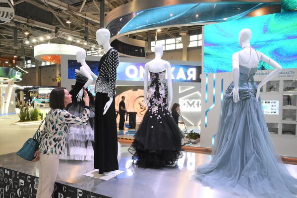 نمایشگاه بین المللی &quot;روسیه&quot;،  یک بازدید کننده لباس ها را در افتتاحیه نمایشگاه نگاه می کند. - اسپوتنیک ایران  