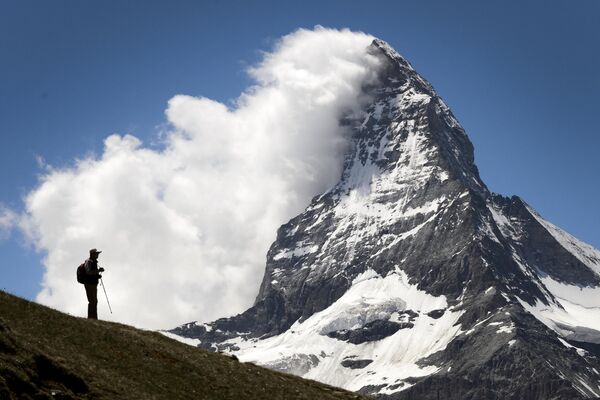 یک گردشگر  در مقابل کوه ماترهورن دیده می شود.  امسال 150 سالگرد اولین صعود به ماترهورن برگزار می شود.این کوه که یکی از بلندترین قله‌ها در کوهستان آلپ را دارد، در مرز سوئیس و ایتالیا قرار گرفته ‌است. - اسپوتنیک ایران  