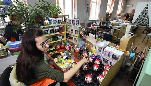 هنرمندان در کارخانه اسباب‌بازی «بیروسینکا»  در کراسنویارسک، تزئینات سال نو را که با استفاده از فناوری‌های کلاسیک ایجاد شده‌اند، نقاشی می‌کنند. - اسپوتنیک ایران  