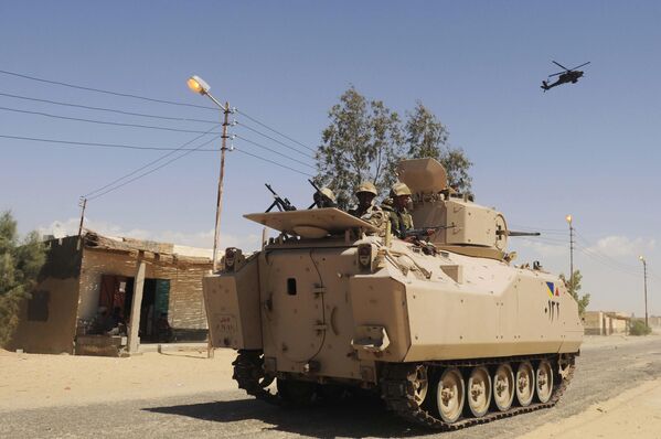 سربازان ارتش مصر در 12 مه 2013در حال گشت زنی در یک خودروی زرهی با پشتیبانی یک فروند هلیکوپتر در شمال صحرای سینا هستند. ستیزه جویان اسلامی در آن زمان موجی از حملات همزمان از جمله بمب گذاری انتحاری با خودروهای بمب گذاری شده را علیه ایست های بازرسی ارتش مصر در شمال شبه جزیره سینا به راه انداخته و ده ها سرباز را کشتند. - اسپوتنیک ایران  