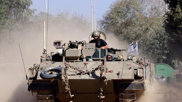 Israeli soldiers ride in an armoured vehicle as it moves into positioned close to the Israel's border with the Gaza Strip, in southern Israel on November 16, 2023. - اسپوتنیک ایران  