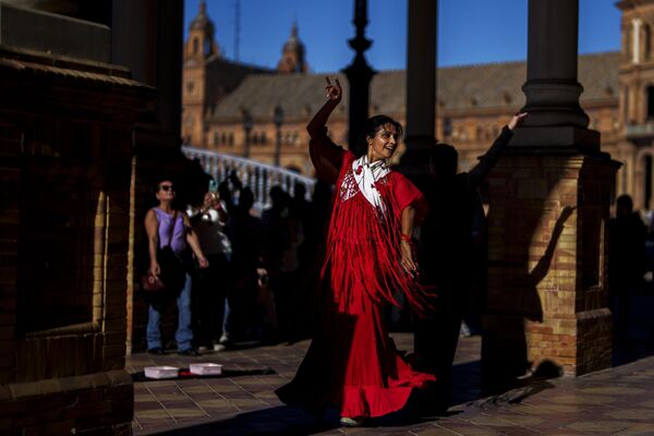 زنی در میدان اسپانیا در سویل، جنوب اسپانیا، در حال رقص فلامنکو و درخواست پول است. 12 نوامبر 2023 - اسپوتنیک ایران  