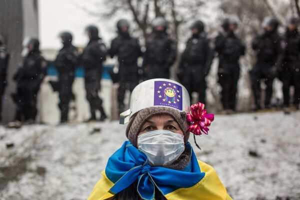 یک شرکت کننده در تجمعات اعتراضی برای ادغام اروپایی اوکراین در خیابان گروشفسکی در کی یف، اوکراین. - اسپوتنیک ایران  