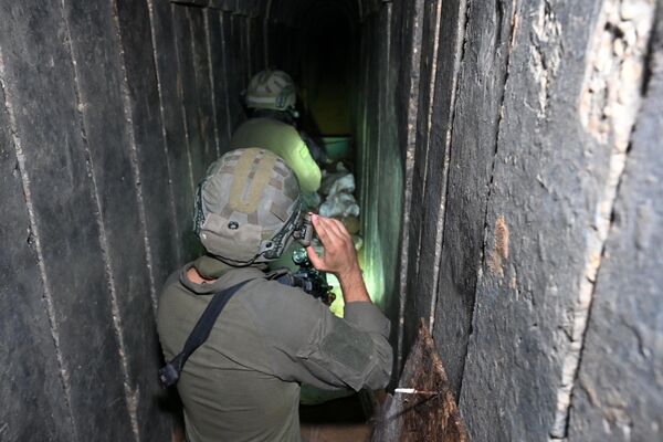 --عکس گرفته شده در طی یک تور کنترل شده و متعاقباً ویرایش شده تحت نظارت ارتش اسرائیل-- سربازان از تونلی عبور می کنند که ارتش اسرائیل می گوید توسط شبه نظامیان حماس در داخل مجتمع بیمارستان الشفا در شمال شهر غزه در غزه حفر شده است. ، در بحبوحه نبردهای ادامه دار بین اسرائیل و گروه شبه نظامی فلسطینی حماس، در 22 نوامبر 2023. (عکس از Ahikam SERI / AFP) - اسپوتنیک ایران  